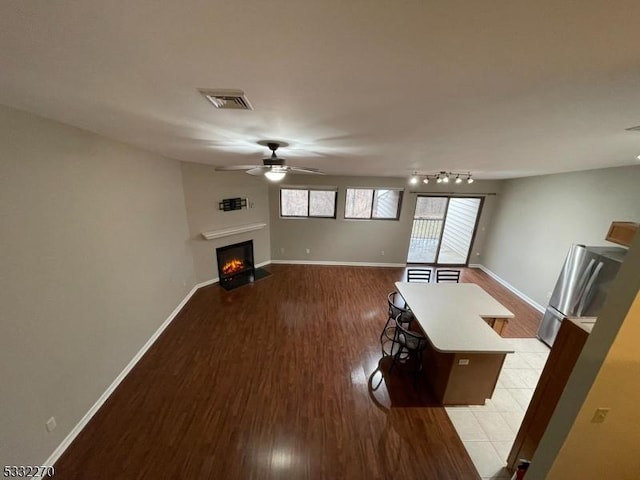 unfurnished living room with ceiling fan and light hardwood / wood-style floors