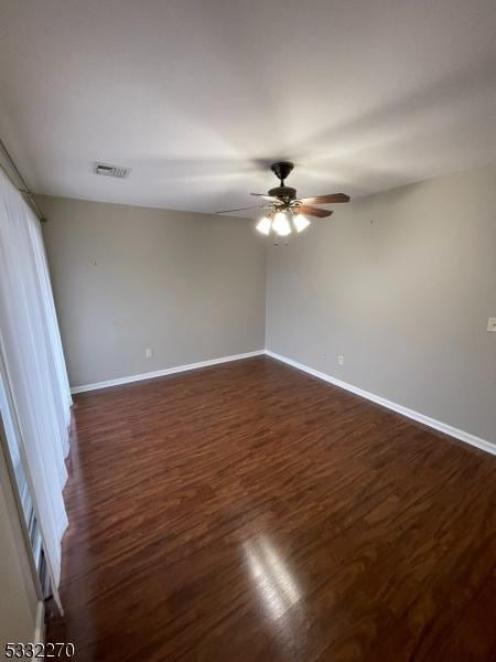 empty room featuring ceiling fan and dark wood-type flooring