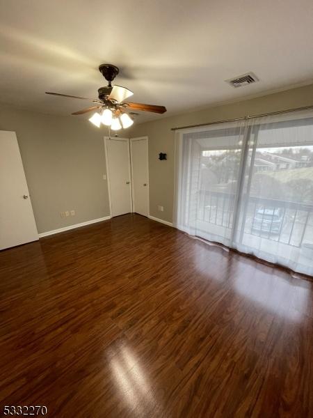 spare room with ceiling fan and dark hardwood / wood-style floors