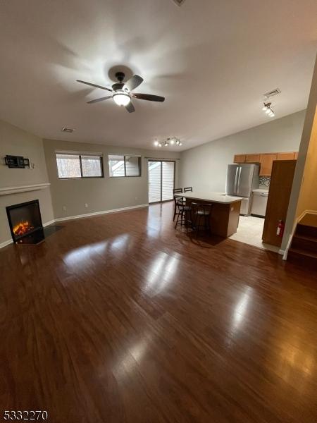 unfurnished living room with hardwood / wood-style floors and ceiling fan