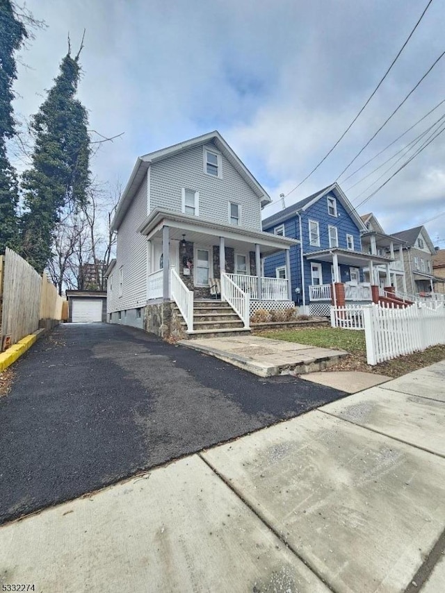 view of front of house with a porch, a garage, and an outdoor structure