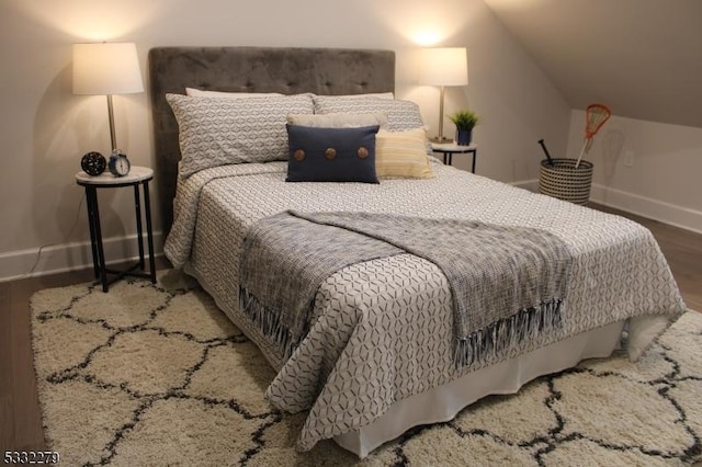 bedroom featuring hardwood / wood-style flooring and lofted ceiling