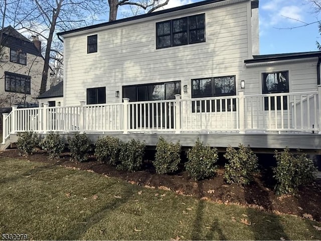 back of house featuring a deck and a yard