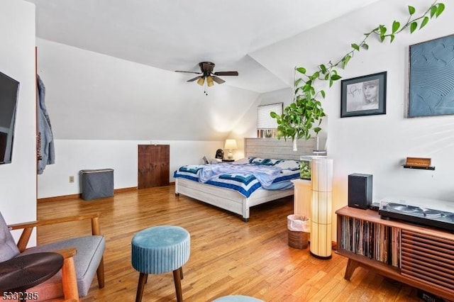 bedroom featuring hardwood / wood-style floors, ceiling fan, and lofted ceiling