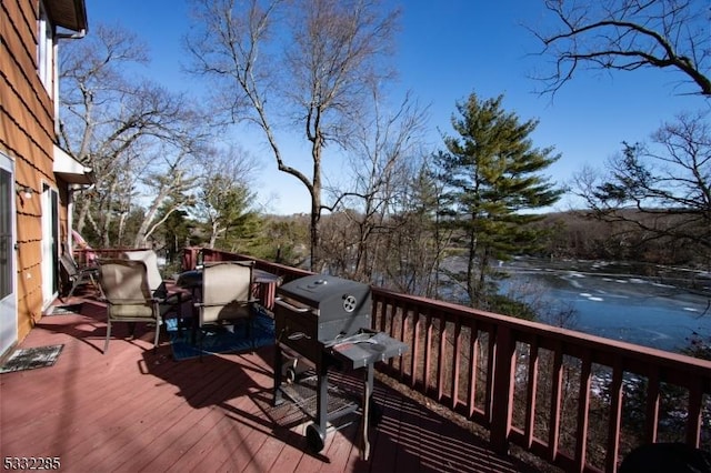 wooden deck with area for grilling and a water view