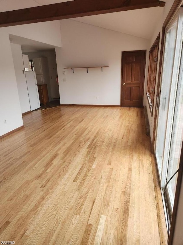 unfurnished room featuring lofted ceiling with beams and light hardwood / wood-style floors