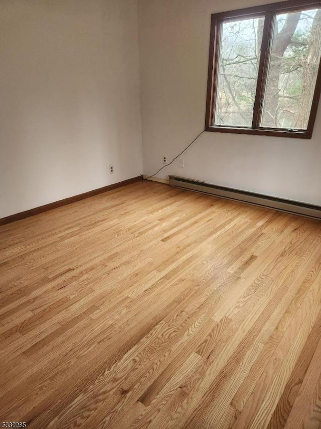 empty room featuring light hardwood / wood-style floors and a baseboard radiator