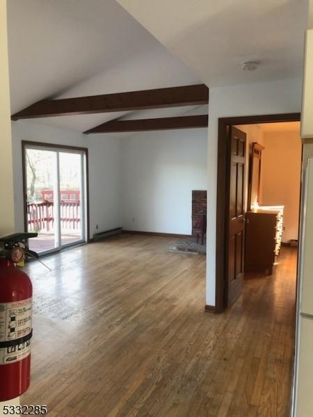 unfurnished living room featuring hardwood / wood-style floors and lofted ceiling