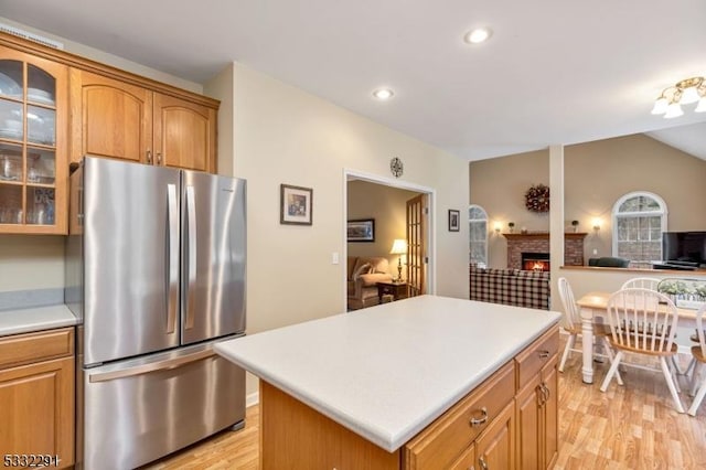 kitchen with a center island, stainless steel refrigerator, and light hardwood / wood-style flooring