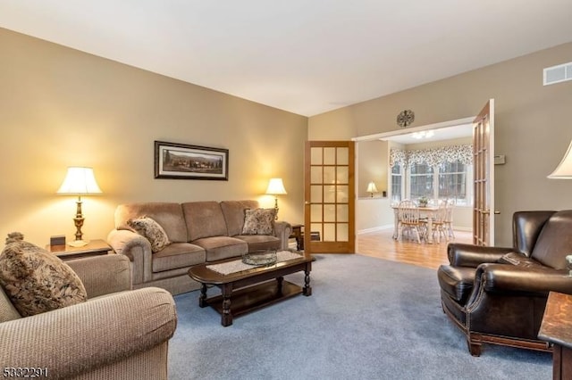 living room with vaulted ceiling, carpet floors, and french doors