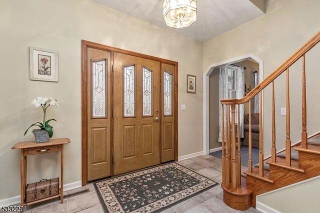 entrance foyer with light tile patterned flooring and a notable chandelier