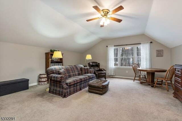 carpeted living room featuring vaulted ceiling and ceiling fan