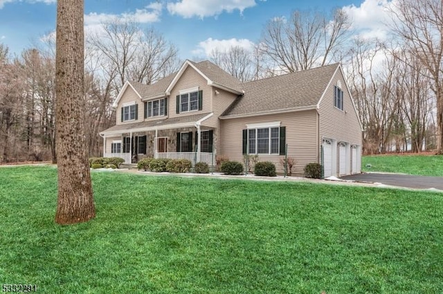 view of property featuring a porch, a front lawn, and a garage