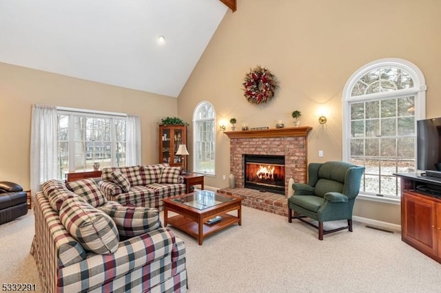 living room with high vaulted ceiling, a brick fireplace, beam ceiling, and light colored carpet