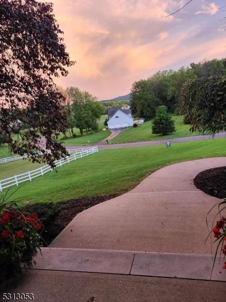 view of property's community featuring a lawn and a rural view