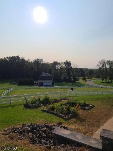 yard at dusk featuring a rural view