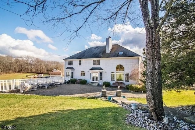 rear view of property with a lawn and a patio