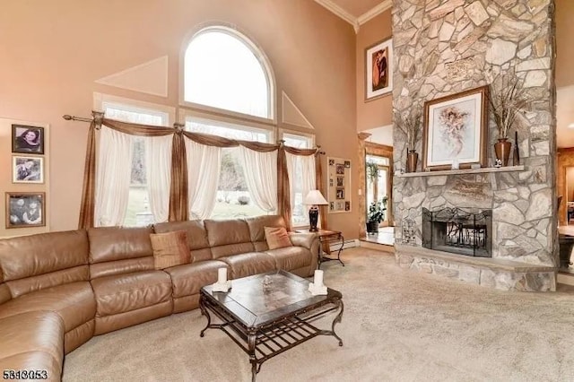 living room featuring a wealth of natural light, a fireplace, crown molding, and a high ceiling