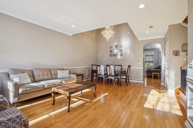 living room with a chandelier, light hardwood / wood-style flooring, and crown molding