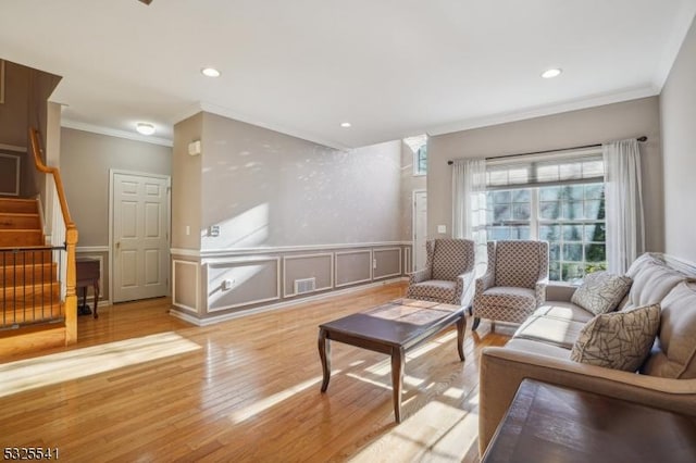 living room with light wood-type flooring and crown molding