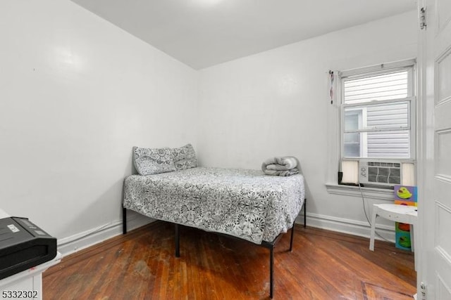 bedroom with cooling unit and dark wood-type flooring