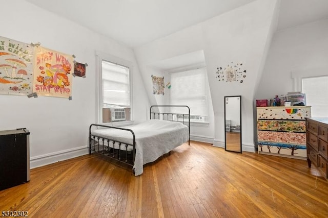 bedroom featuring cooling unit, multiple windows, and light wood-type flooring