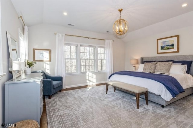 bedroom with lofted ceiling and a chandelier