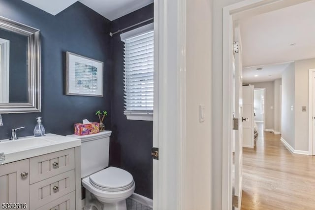 bathroom featuring vanity, toilet, wood-type flooring, and plenty of natural light