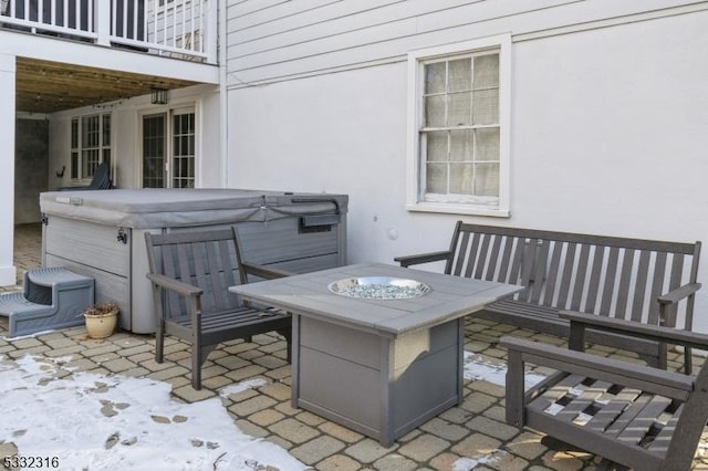 view of patio / terrace featuring a hot tub, a balcony, and an outdoor fire pit