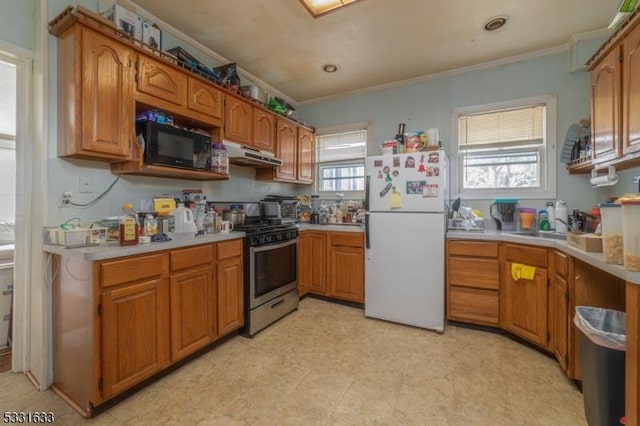 kitchen featuring white fridge, ornamental molding, and gas range