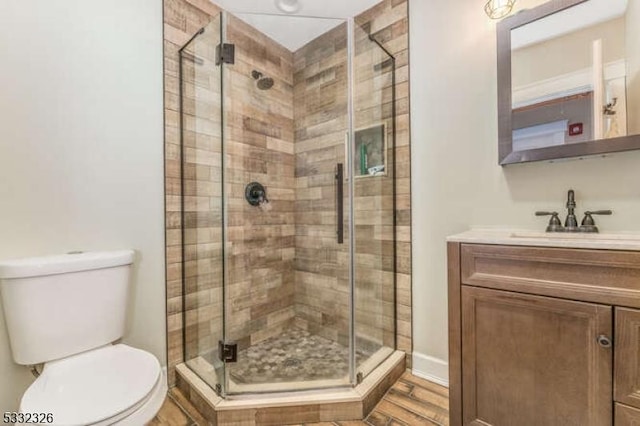 bathroom featuring vanity, toilet, and walk in shower