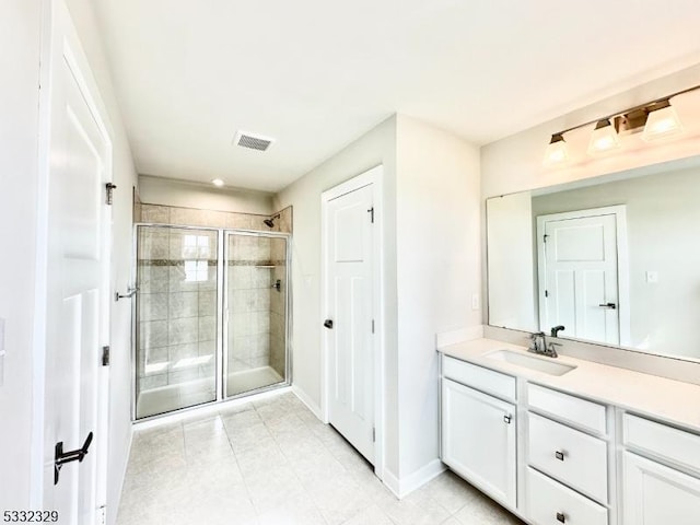 bathroom with an enclosed shower, vanity, and tile patterned floors