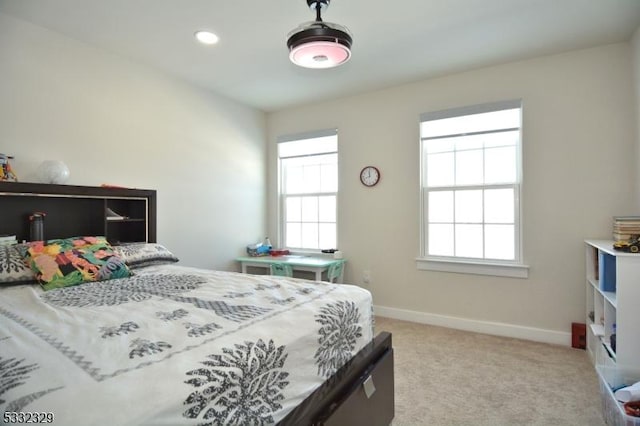 bedroom featuring light carpet and multiple windows