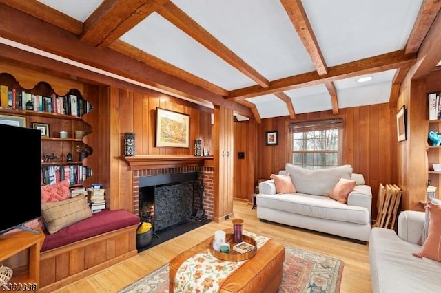 living room with a fireplace, light wood-type flooring, beamed ceiling, and wood walls