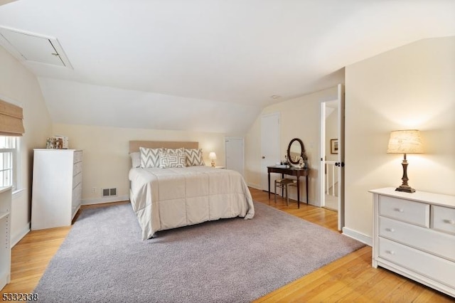 bedroom featuring light wood-type flooring and vaulted ceiling