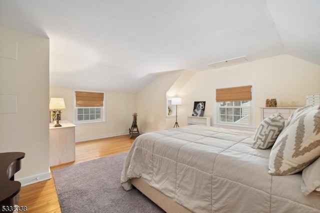 bedroom featuring lofted ceiling and light wood-type flooring