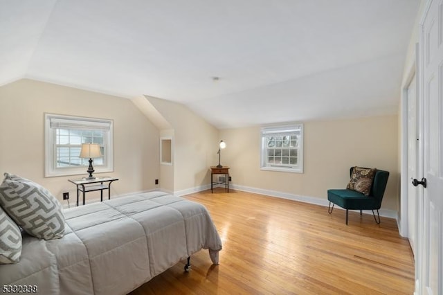 bedroom with lofted ceiling and light hardwood / wood-style floors