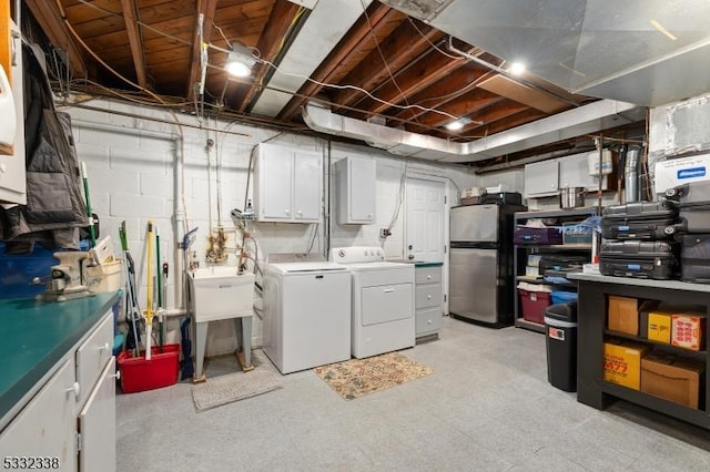 basement featuring stainless steel fridge and independent washer and dryer