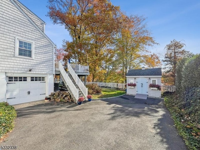 view of yard with a garage, a wooden deck, and a storage shed