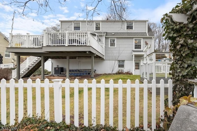 back of house featuring cooling unit, a deck, and a yard