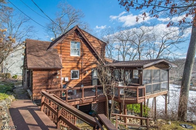 back of property featuring a wooden deck and a sunroom