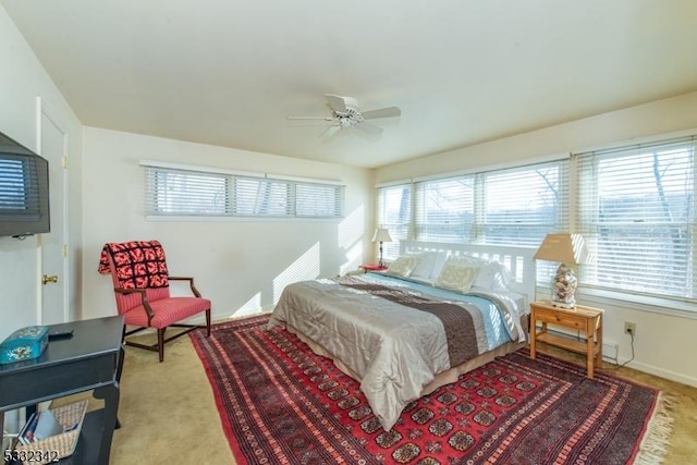 bedroom with ceiling fan, light colored carpet, and multiple windows