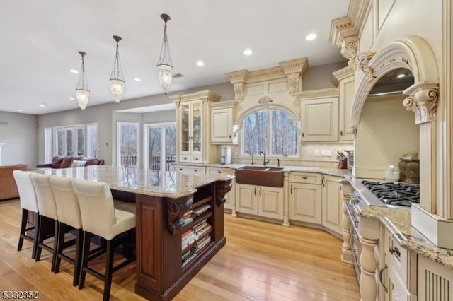 kitchen featuring sink, hanging light fixtures, cream cabinets, and a kitchen island