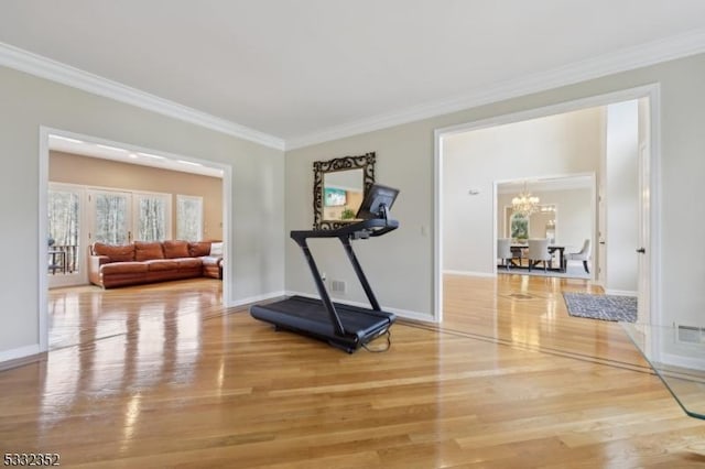 workout area with an inviting chandelier, ornamental molding, and wood-type flooring