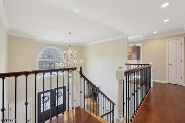 corridor with french doors, a chandelier, ornamental molding, and dark wood-type flooring