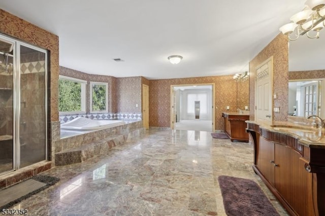 bathroom featuring shower with separate bathtub, a chandelier, and vanity