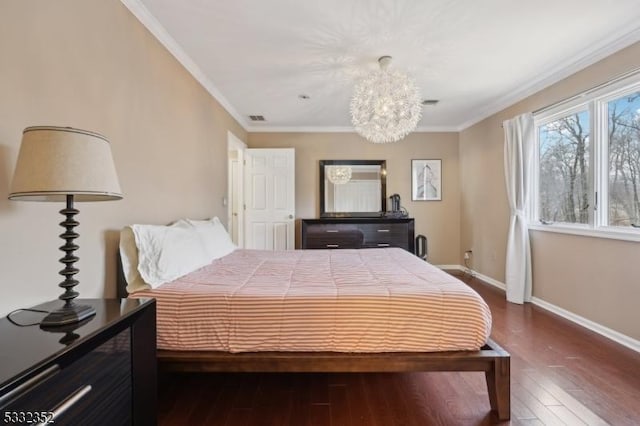 bedroom with dark wood-type flooring, a notable chandelier, and ornamental molding