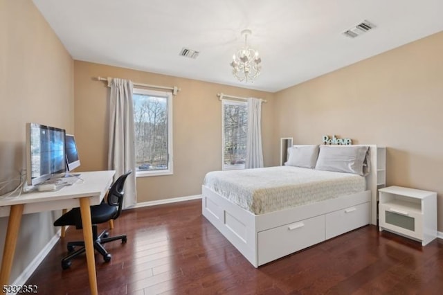 bedroom featuring an inviting chandelier and dark hardwood / wood-style floors