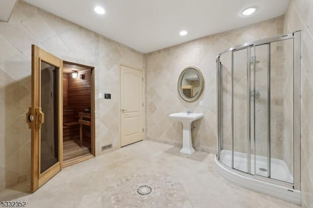 bathroom with tile walls and an enclosed shower