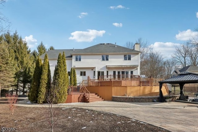 rear view of property featuring a gazebo and a wooden deck